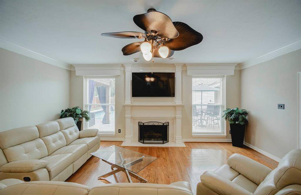 Enjoy a bright, inviting living room with elegant wood flooring and expansive windows, all complemented by neutral tones.