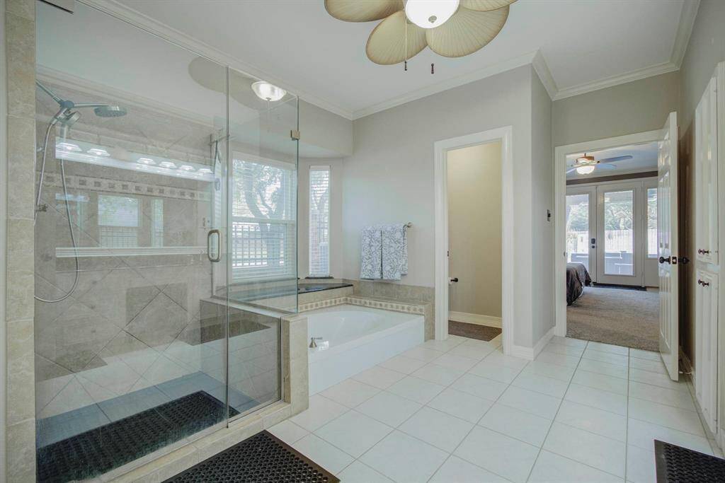 Luxurious primary bathroom featuring a spacious walk-in shower and elegant soaking tub.