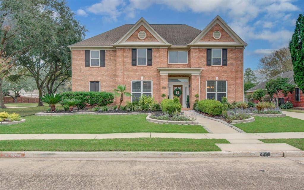 Discover this charming two-story brick home in Marina Bay Park, featuring a symmetrical façade, inviting entrance, and large windows. Enjoy the beautifully maintained landscaping and spacious green lawn, offering serene curb appeal.