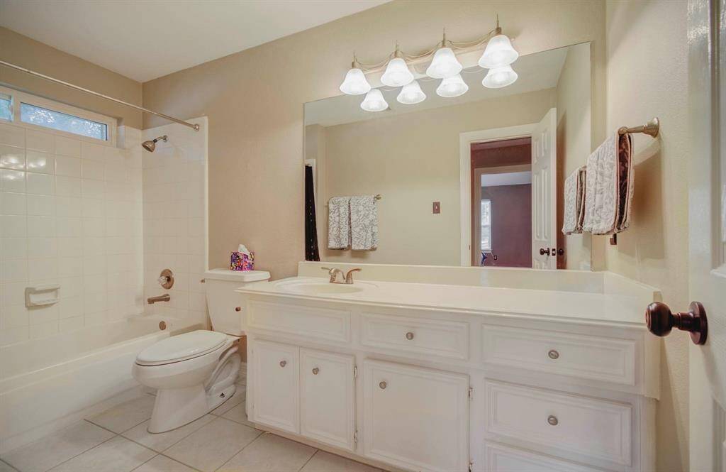 Spacious hall bathroom featuring a tub/shower combo and abundant storage.