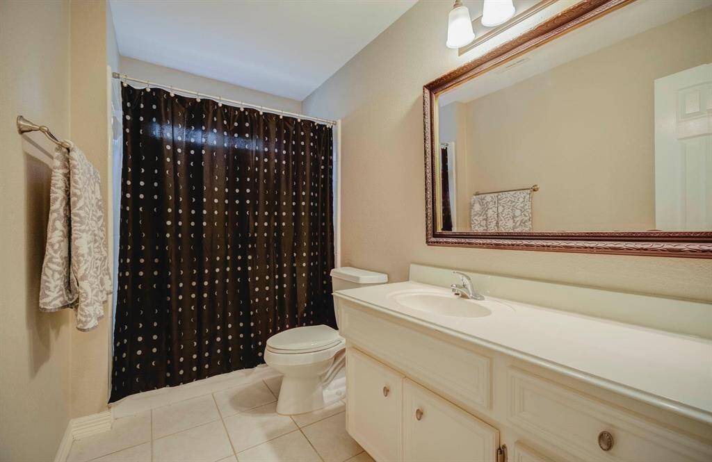 Spacious third full bathroom with ample storage.