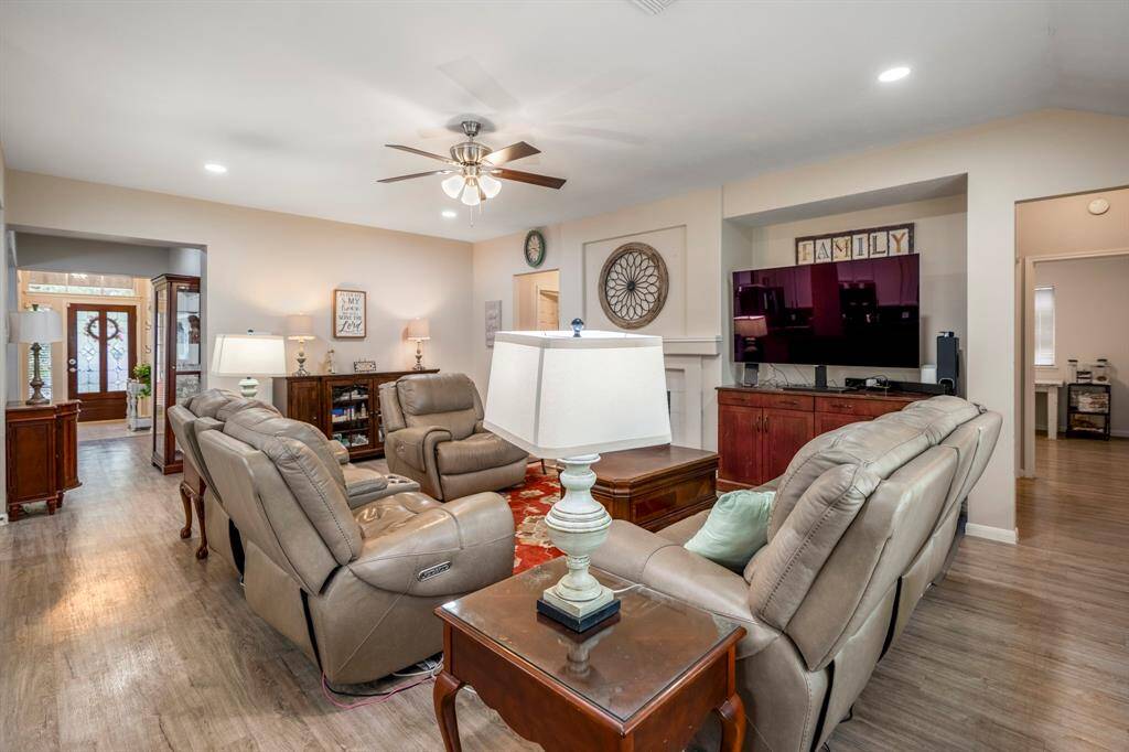 Moving into the family room from the breakfast area, to the left, you can see the front door, while to the right, a hallway leads to the primary suite and another bedroom, offering a well-connected and functional layout.