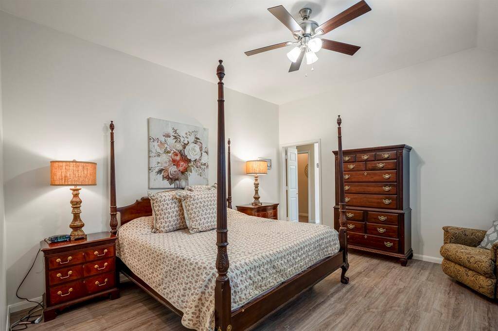 The spacious primary bedroom features no carpet, a ceiling fan, and raised ceilings, creating an open and comfortable retreat with a clean, modern feel.