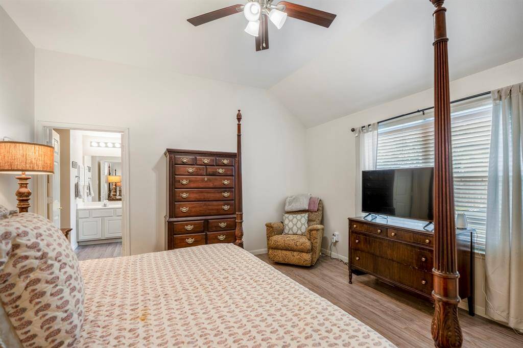 Another view of the primary suite, featuring a large window that overlooks the backyard, allowing plenty of natural light. To the left, you can see through the doorway into the primary bath, creating a seamless connection between the two spaces.