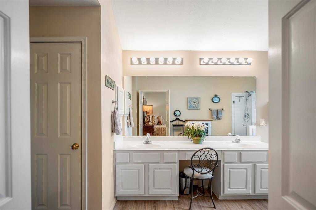 Entering the primary bath, you'll notice the dual sinks with a vanity area for added convenience. To the left is a doorway leading to the potty closet, while the linen and walk-in closets are tucked out of view. To the right, the shower is reflected in the mirror, enhancing the spacious and functional layout.