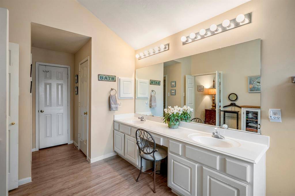 A closer look at the vanity area, featuring a medicine cabinet for added storage. Beyond the vanity, you can see the doors to the linen closet and potty closet, offering convenient access to essential spaces within the primary bath.
