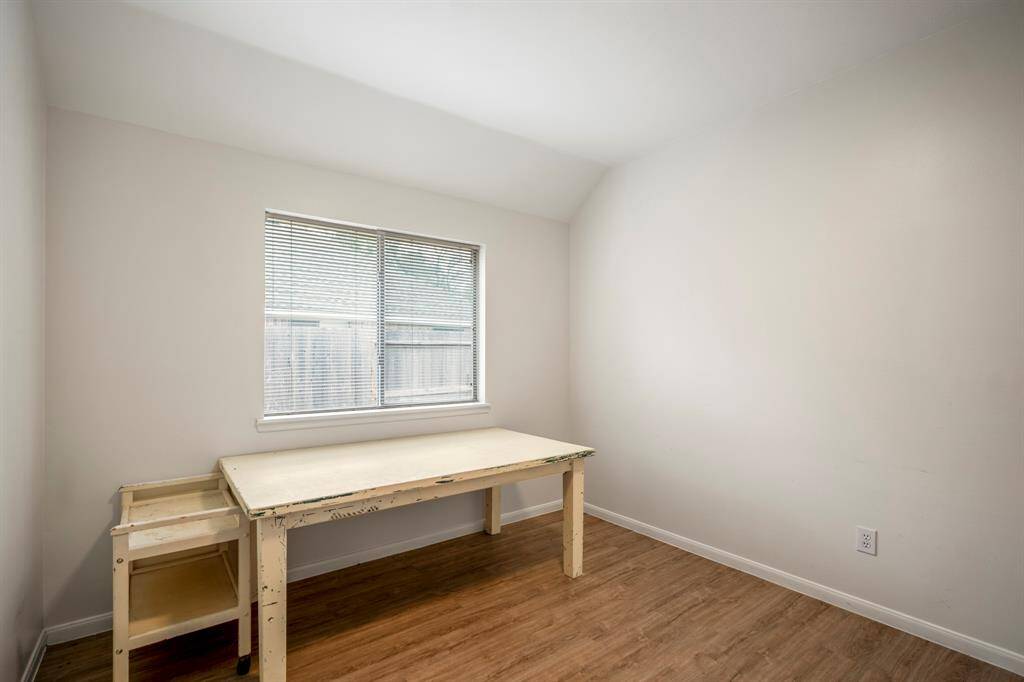 A secondary bedroom located next to the primary suite, featuring no carpet and a spacious walk-in closet. This room offers both comfort and functionality.