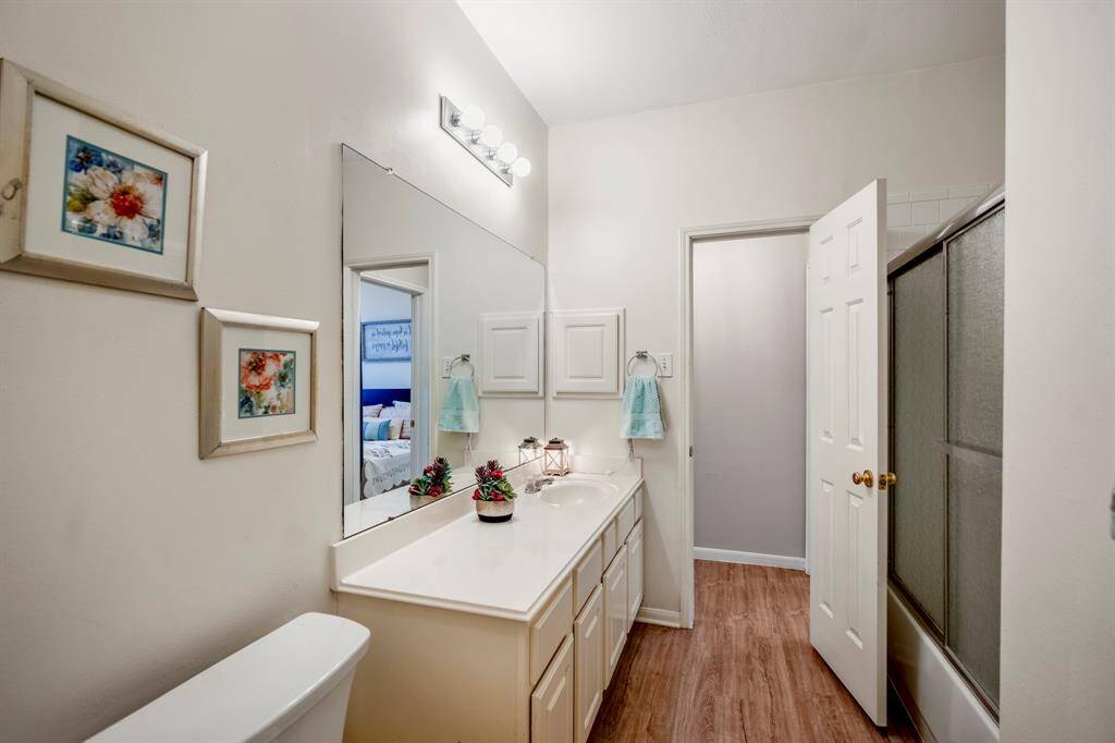 The secondary bathroom conveniently connects between the two hallway areas, providing easy access to both the third bedroom and the spaces with the primary bedroom and second bedroom, offering a functional layout.