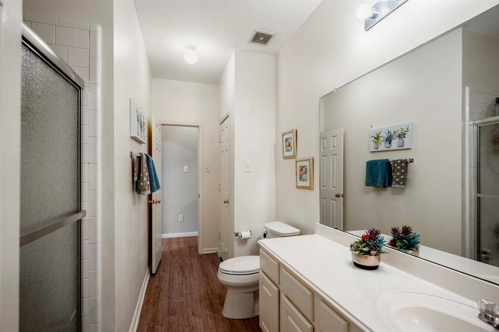 Another view of the secondary bathroom, highlighting the ample counter space and the convenient linen closet, offering both practicality and storage in this well-appointed space.