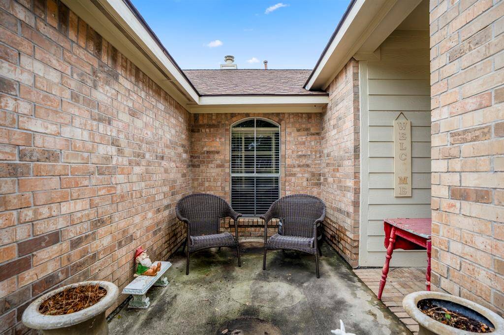 A close-up of the inviting concrete patio sitting area by the front door, offering a great spot to relax and enjoy the outdoors in comfort.