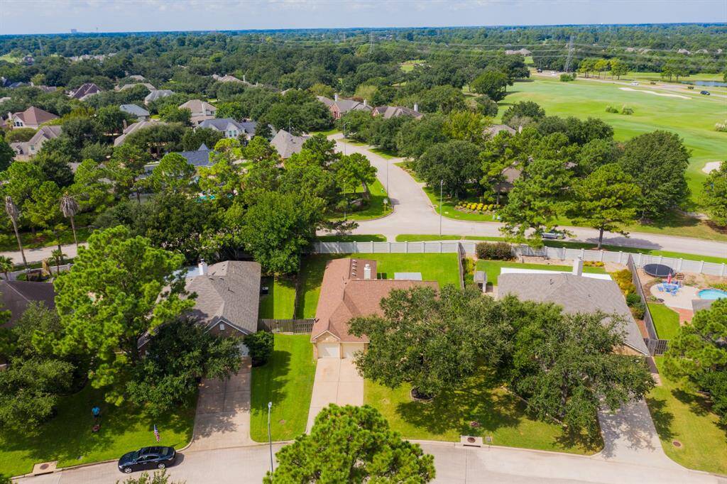 A similar aerial view, showcasing the home’s private backyard with no rear neighbors, and a beautiful glimpse of the Windrose Golf Course in the distance, enhancing the peaceful atmosphere of the property.