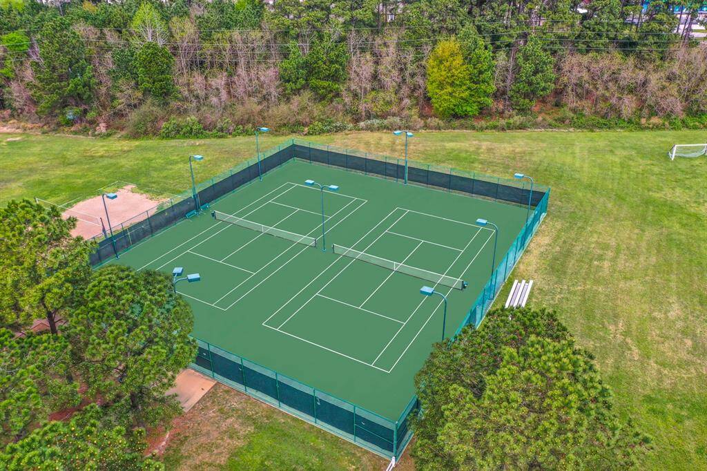 Enjoy an aerial view of our community tennis courts in Windrose, where residents can engage in friendly matches and stay active. Part of a vibrant community hub that also features pools, a Meeting House, and ample green space for all your recreational needs.