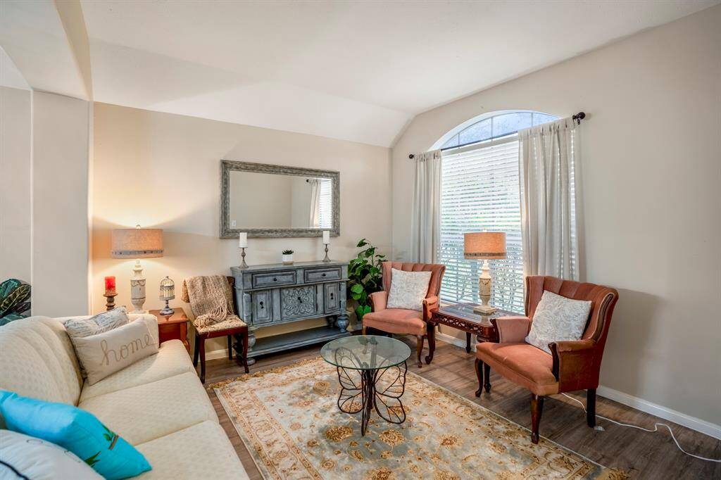 A glimpse into the formal living area, featuring a large window that brings in natural light and offers a lovely view of the front yard.