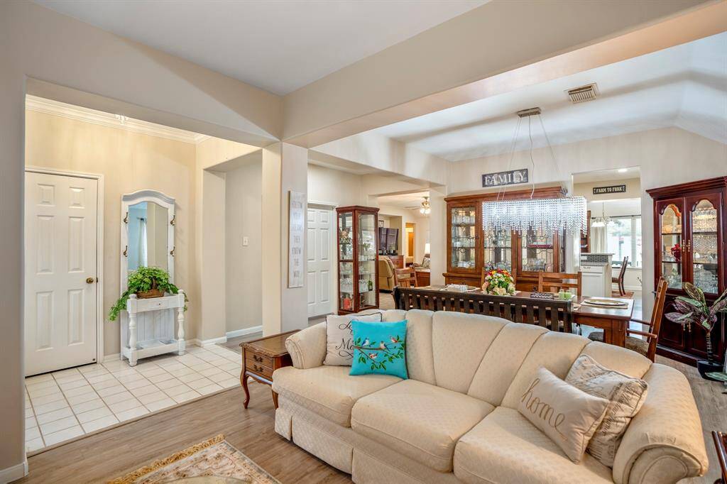 From the formal living area, enjoy a seamless flow into the adjoining formal dining room. Through the doorway, a glimpse of the kitchen awaits, while the family room is just beyond the entryway, creating an open and inviting layout perfect for both everyday living and entertaining.