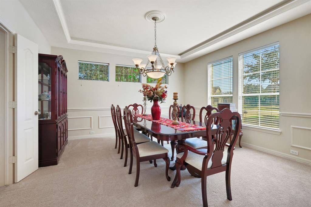Kitchen features beautiful granite countertops, island with gas cook top, raised dishwasher and charming pendant lighting