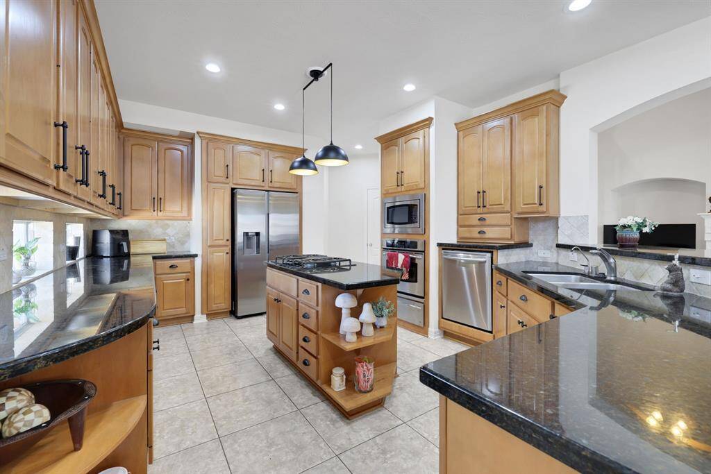 Kitchen is charming with natural wood colored cabinets and the dark granite creating a contract.