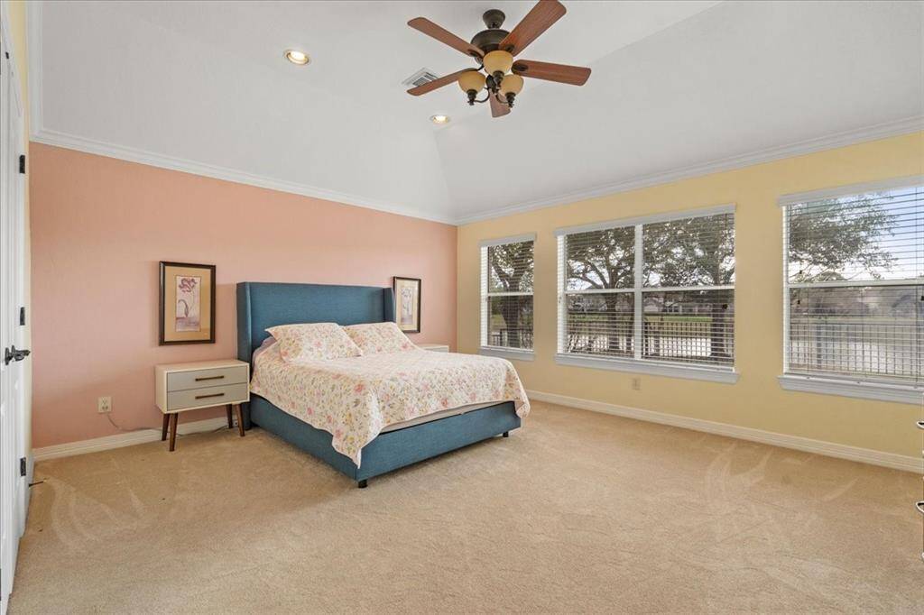 Primary bedroom with a wall of windows to enjoy the serene lake view