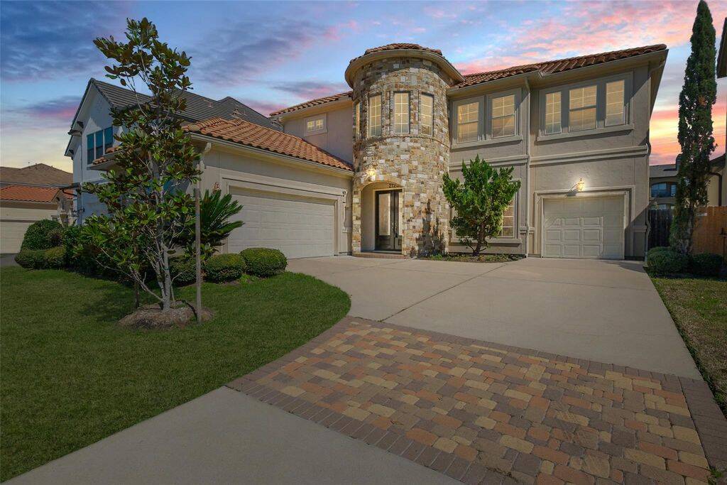 Step into luxury with this stunning Mediterranean-style home, boasting a grand stone turret entry and a beautifully manicured front yard. The eye-catching façade features a blend of stucco and stone, complemented by classic clay tile roofing for a timeless appeal. A spacious driveway leads to a three-car garage, offering ample parking and storage.