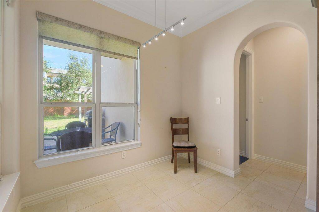 Start your mornings in this bright and inviting breakfast room, where large windows frame picturesque views of the lush backyard. Sunlight pours into the space, creating a warm and cheerful ambiance perfect for casual dining or enjoying your morning coffee.