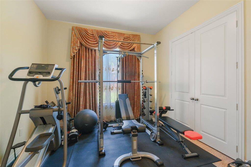 Currently set up as a home gym, this flexible first-floor bedroom offers endless possibilities to suit your lifestyle. Whether you need a nursery, a private in-law suite, or a cozy guest retreat, this space adapts effortlessly to your needs.Featuring neutral walls, elegant draped curtains, and double doors for added privacy, the room exudes both comfort and functionality. Natural light enhances the inviting atmosphere, while the en-suite bathroom provides ultimate convenience.