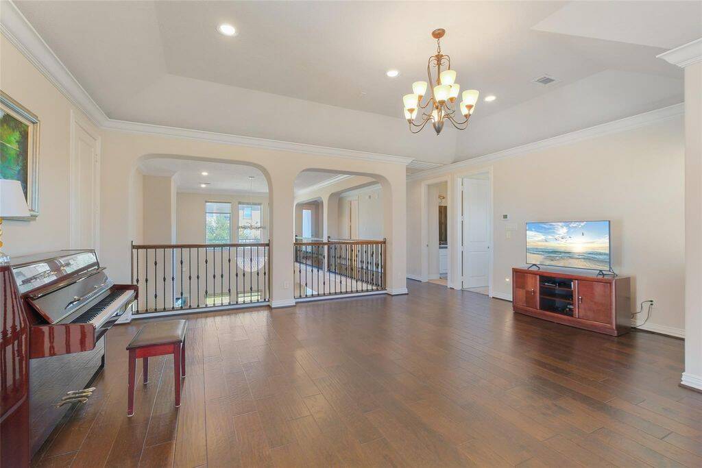 The open railing with wrought iron balusters overlooks the grand living area below, enhancing the open-concept feel and allowing natural light to flow effortlessly throughout. Graceful archways lead to additional rooms, while large windows provide a bright and airy ambiance.Whether you're looking for a quiet retreat, a play area, or a stylish entertainment hub, this multi-functional loft is ready to adapt to your lifestyle.
