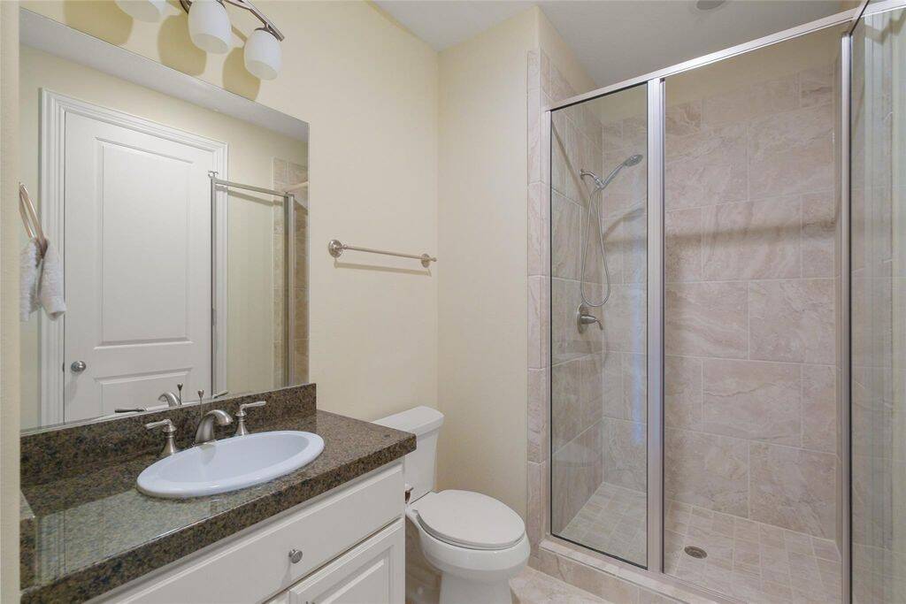 This stylish en-suite bathroom boasts a sleek and contemporary design, perfect for both comfort and functionality. A granite countertop with an elegant undermount sink is complemented by chrome fixtures, adding a touch of sophistication to the space. Designed with both style and convenience in mind, this en-suite bathroom is a perfect complement to the adjacent bedroom.