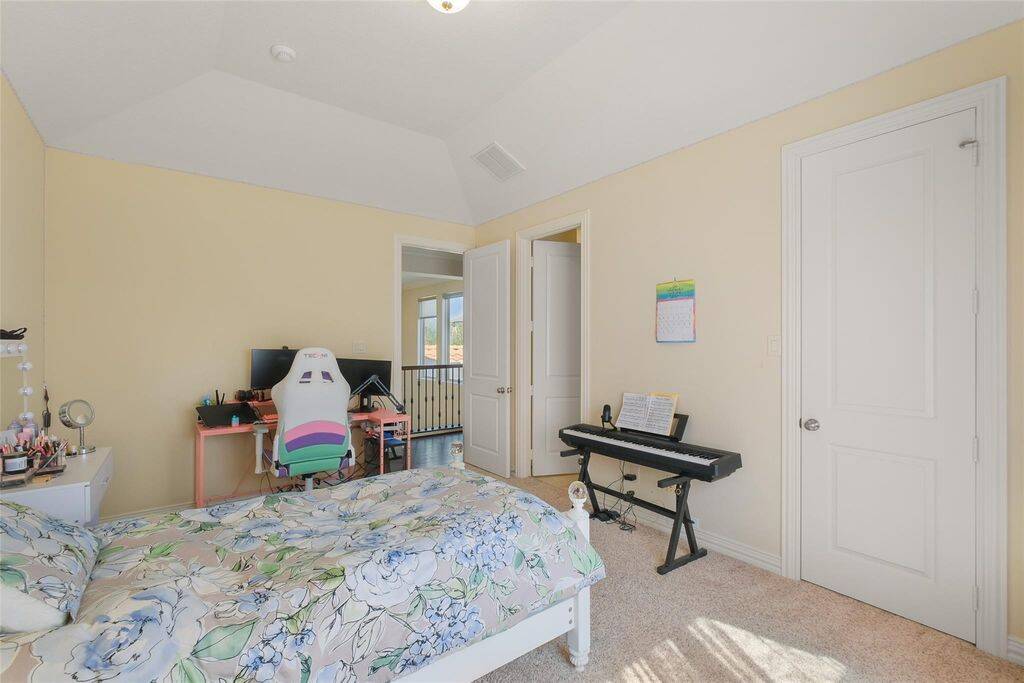 This bright and spacious bedroom features a vaulted ceiling and neutral walls, creating an open and airy ambiance.Whether used as a personal sanctuary, creative space, or gaming retreat, this bedroom is designed to adapt to your needs.