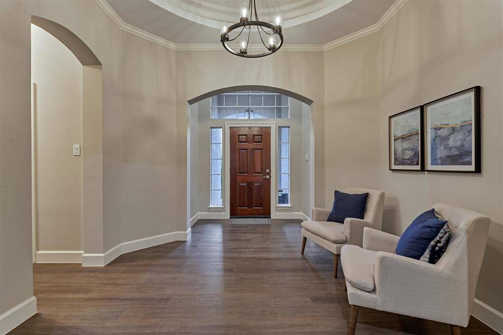 The foyer features a statement chandelier as you enter into an alcove of the entryway.