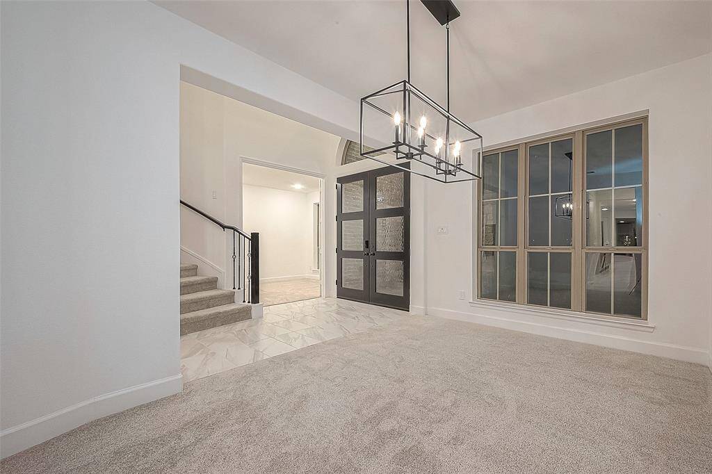 The heart of the home, the two-story family room, boasts soaring 19-foot ceilings and a large wall of windows, flooding the space with natural light.