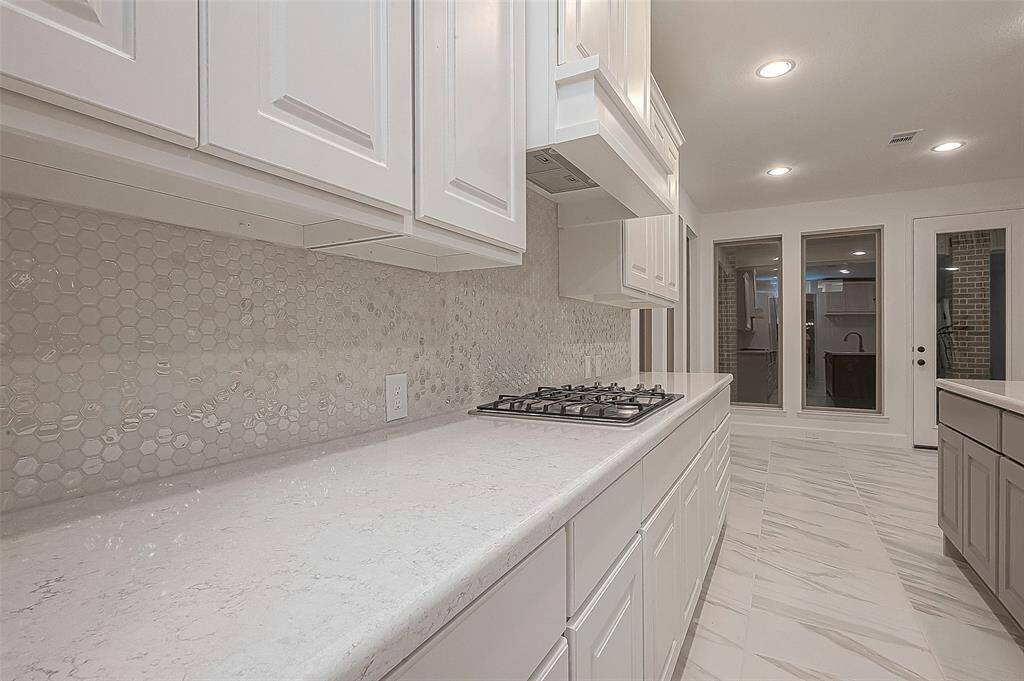 An attached Butler’s pantry with glass display cabinets, a separate walk-in pantry, and pendant lights complete the space.