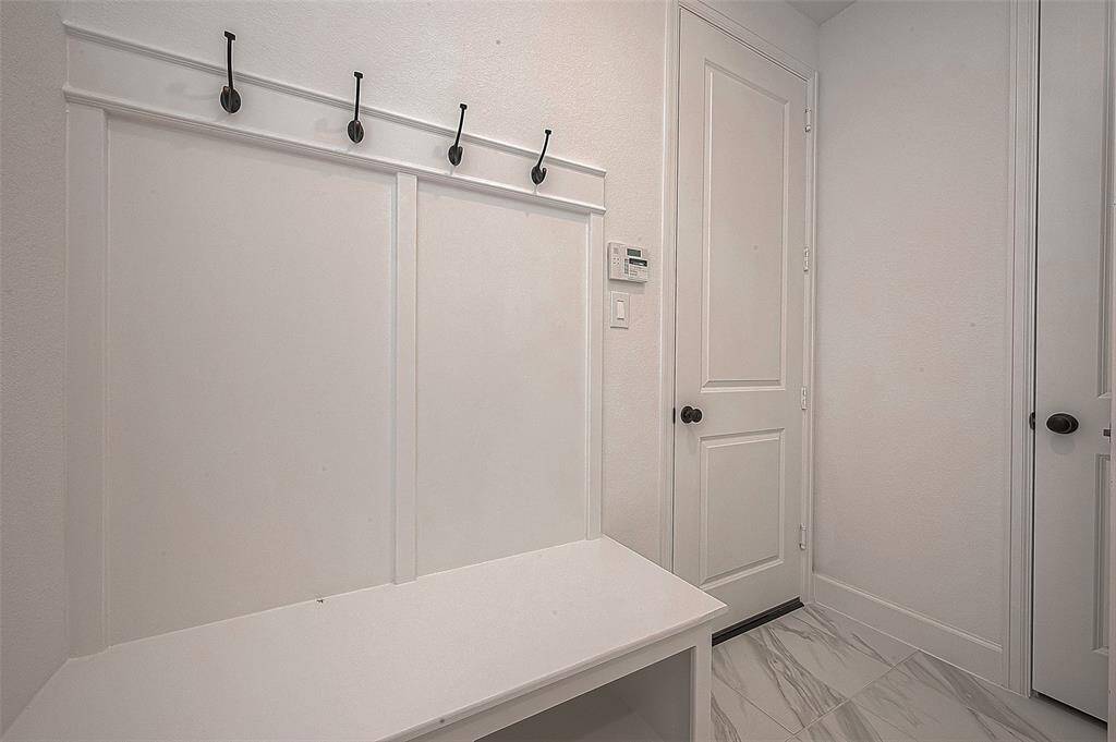 The primary suite, located on the main floor, offers a serene retreat with its 12-foot ceiling, a wall of windows, and plush carpeting.
