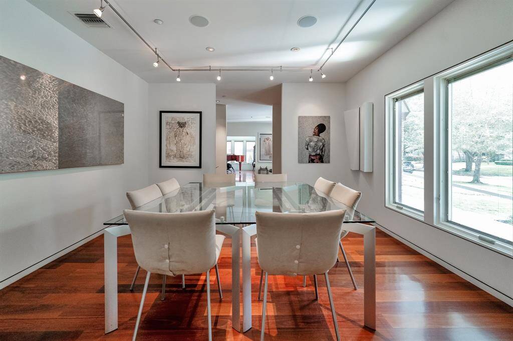 The dining room has natural light and is adorned with adjustable lighting, perfectly curated to showcase your cherished art collection.