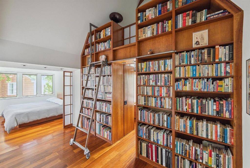 The primary suite has a space for all of your favorite books and a loft that is currently used as a music toom. The doorway in between leads to one of the closets.