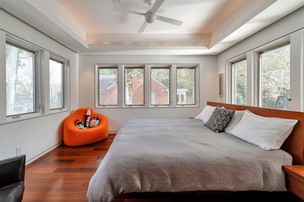 The primary bedroom offers lots of natural light and has motorized shades that come down, in addition to the blinds, to provide complete privacy from the world outside.