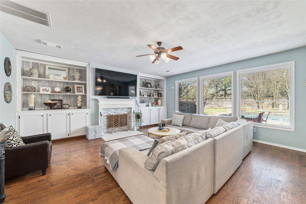 Large living room with built in shelves and cabinets and gas log fireplace