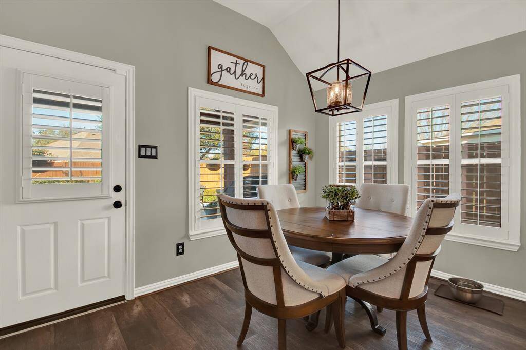 The dining area features modern pendant lighting and large windows with plantation shutters for ample natural light.