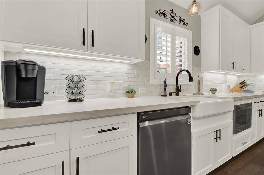 Features include a farmhouse sink, under-cabinet lighting, and a well-lit, spacious countertop.