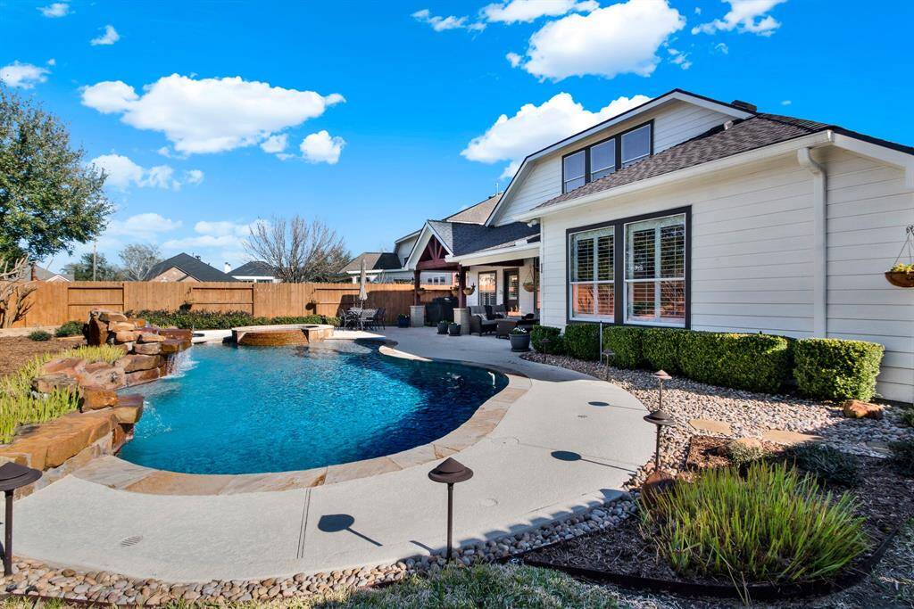 The house exterior features large windows and a neatly landscaped garden, offering a perfect blend of relaxation and style.