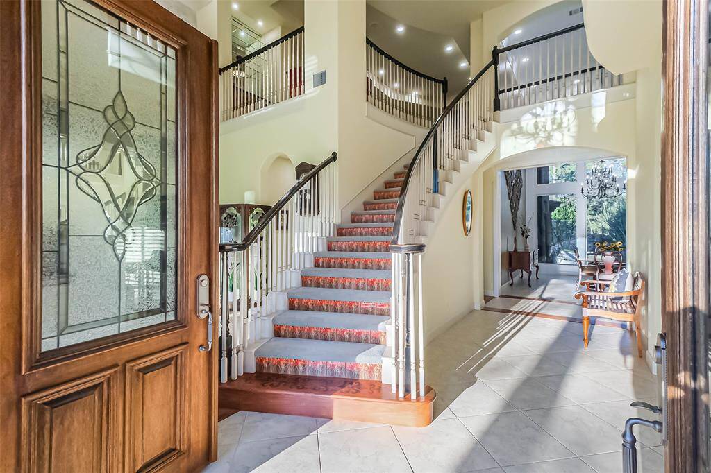 The spacious entryway is welcoming and bright featuring double wood entry doors and a two story entry.
