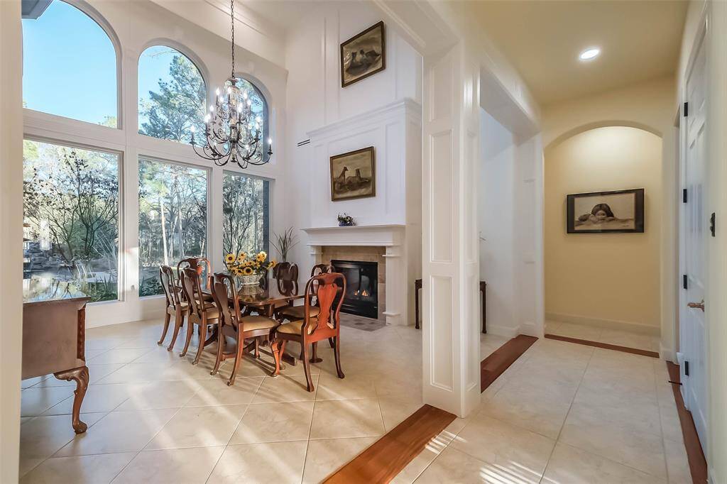 This room is currently the formal dining room where you can overlook the backyard and enjoy the fireplace. The paneled walls and chandelier create the perfect scene for an upscale dining experience at home.