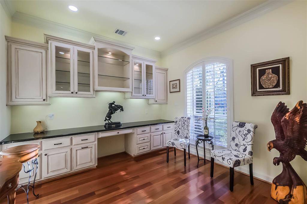 This stunning home office has been perfectly styled in a neutral color palette with plenty of storage to keep your work area looking tidy. The arched window with plantation shutters overlooks your massive front lawn.