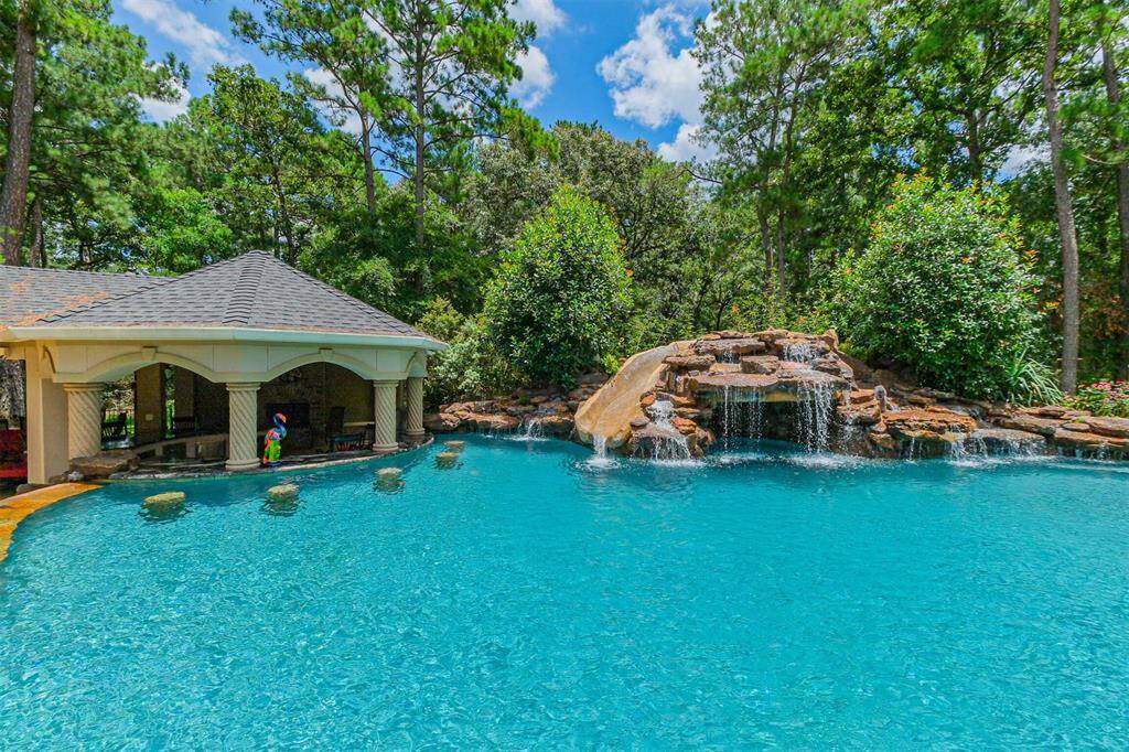 This resort style pool provides hours of entertainment for all ages. This heated pool features a water slide around the rock waterfalls and grotto, a swim up bar with underwater seating for 5, a seated in-pool bar with umbrella, an enormous tanning ledge and a reverse infinity edge to enjoy the waterfall sound around the firepit and pavilion.