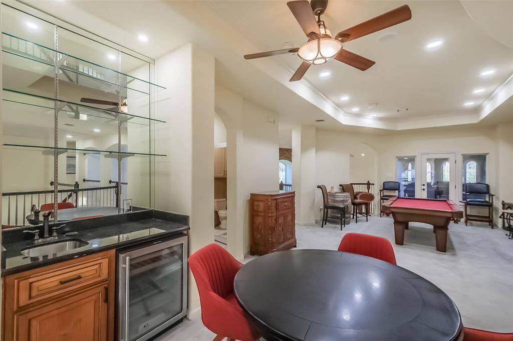 The gameroom’s wet bar has glass shelving and a beverage fridge so you can keep the game moving and not have to run downstairs for refills.