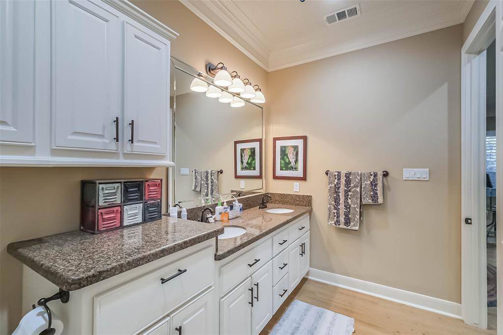 The guest suite full bathroom features two sinks, granite counters and lots of storage.