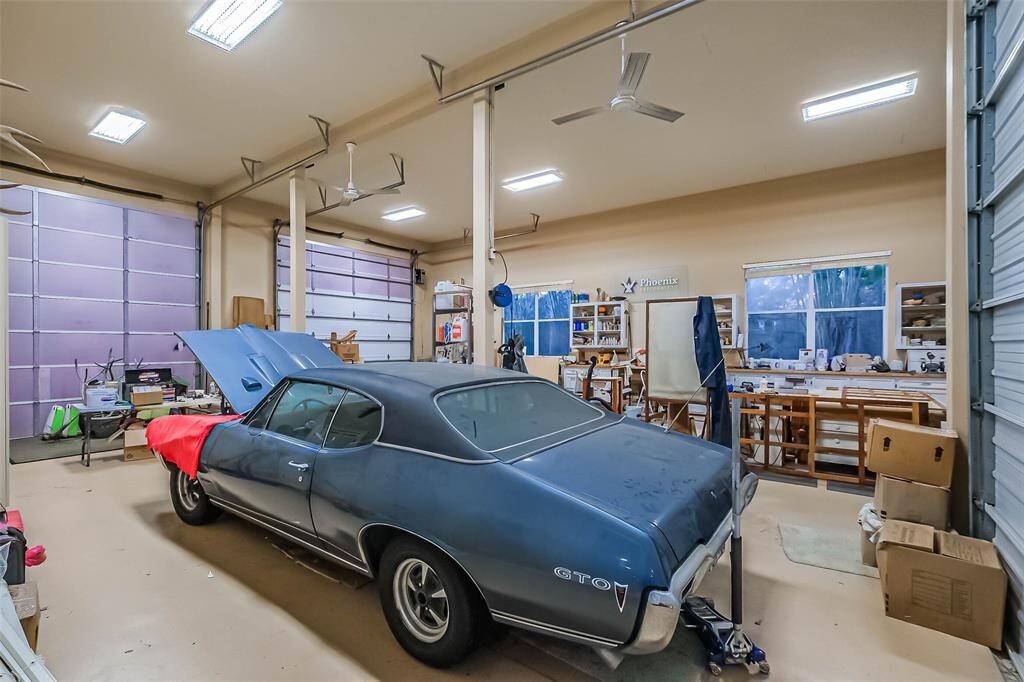 Inside of the double RV garage. Notice the doors, ceiling fans, lighting and shelving.