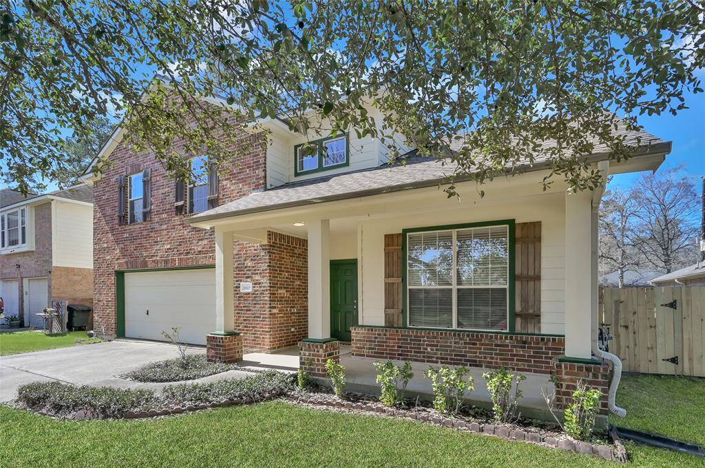This photo showcases a welcoming front porch with a green door, surrounded by brick accents and large windows. The space is bright and open, providing a charming entrance to the home.