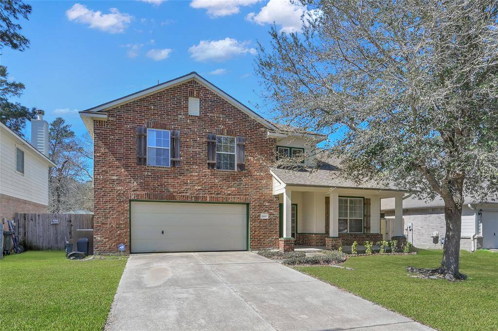 This is a two-story brick home featuring a two-car garage, a covered front porch, and a stately tree in your front yard. Ideal for families seeking a charming and functional space.