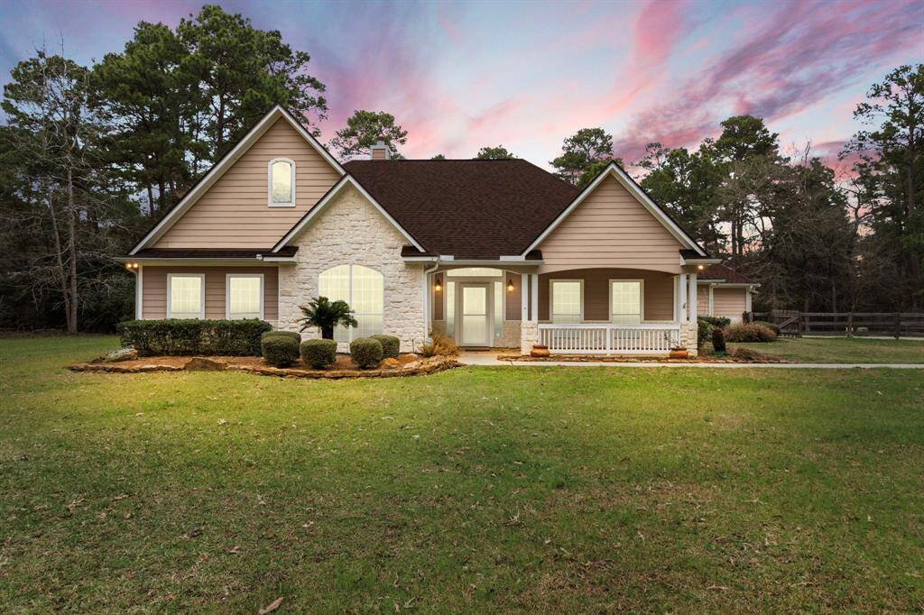 This inviting home features a charming blend of stone and siding, with a welcoming front porch. Set against a backdrop of mature trees, it offers a spacious front yard and a serene atmosphere, perfect for enjoying a peaceful lifestyle.