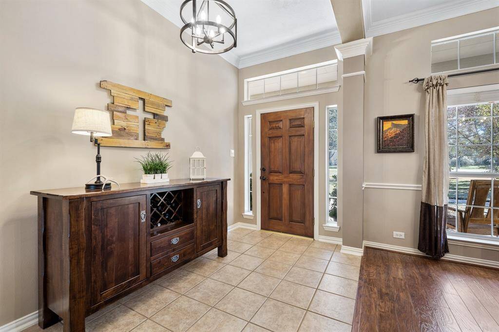 The Foyer is light and bright thanks to the sunlight spilling in through the sidelights and transom window surrounding the solid wood front door. The space is large enough to accommodate a coat rack, bench, or storage piece.