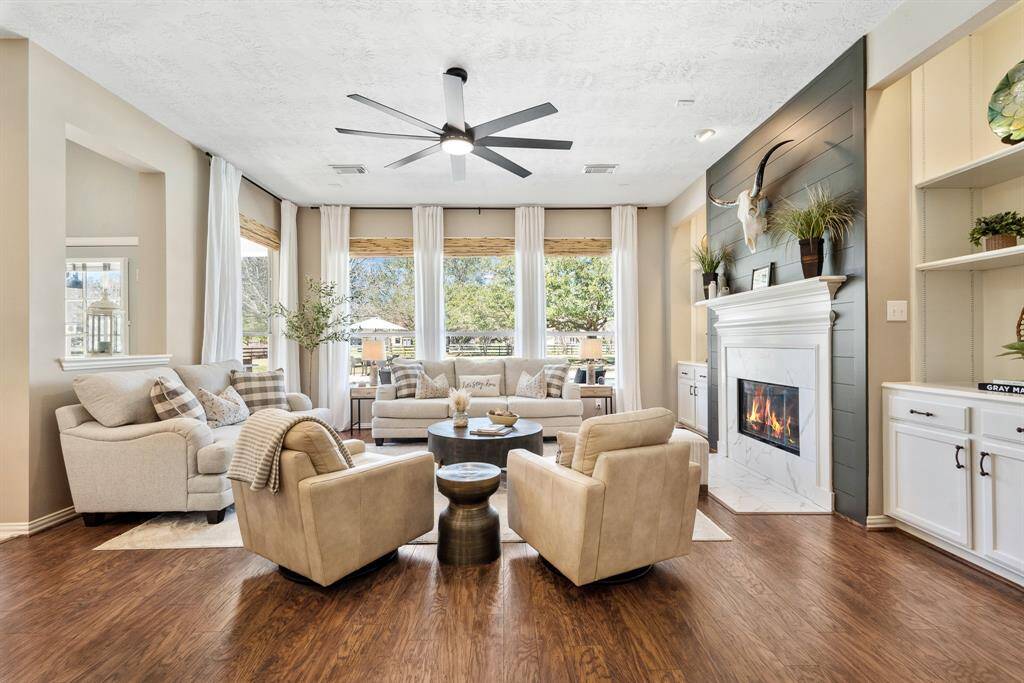 The Living Room is warm and inviting! The eyes are immediately drawn outwards through the quartet of windows ahead, overlooking the lush and spacious Backyard oasis beyond. A cozy and inviting space like this encourages gathering and making memories with the ones you love.